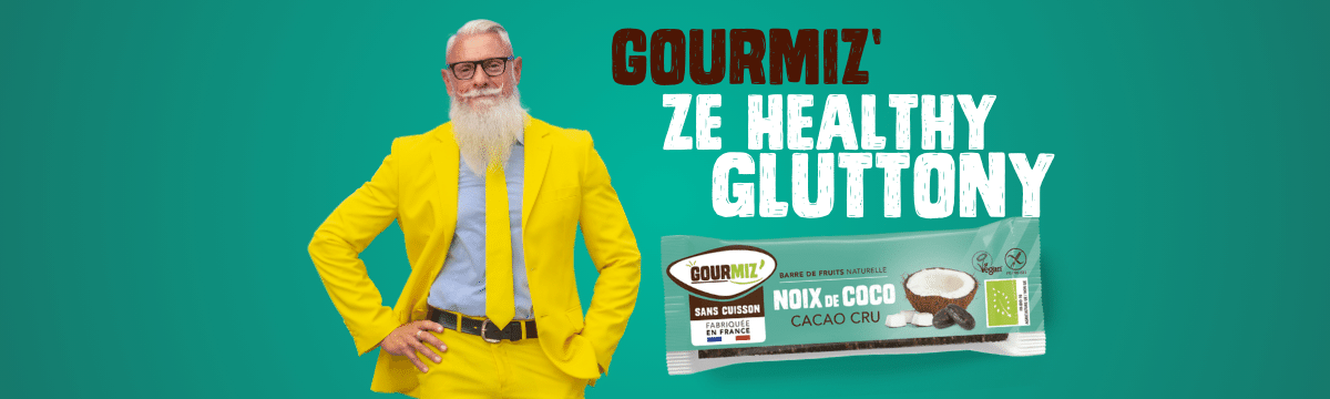 A man in a yellow suit with a white beard and a hand on his hip. It says Gourmiz' ze healthy gluttony